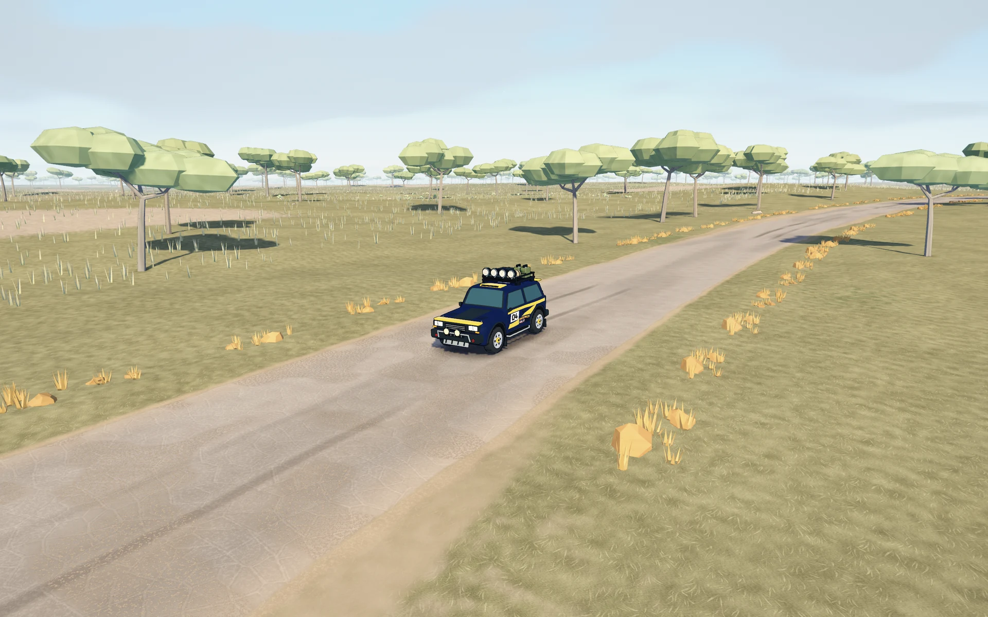 The navy and yellow Atlas Raid on a road through golden grassland and umbrella-shaped trees.